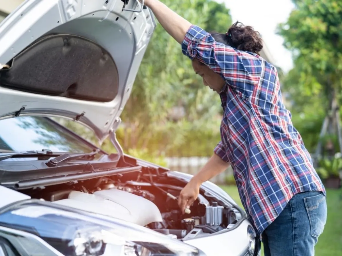 A woman checking for any internal vehicle damage after a crash