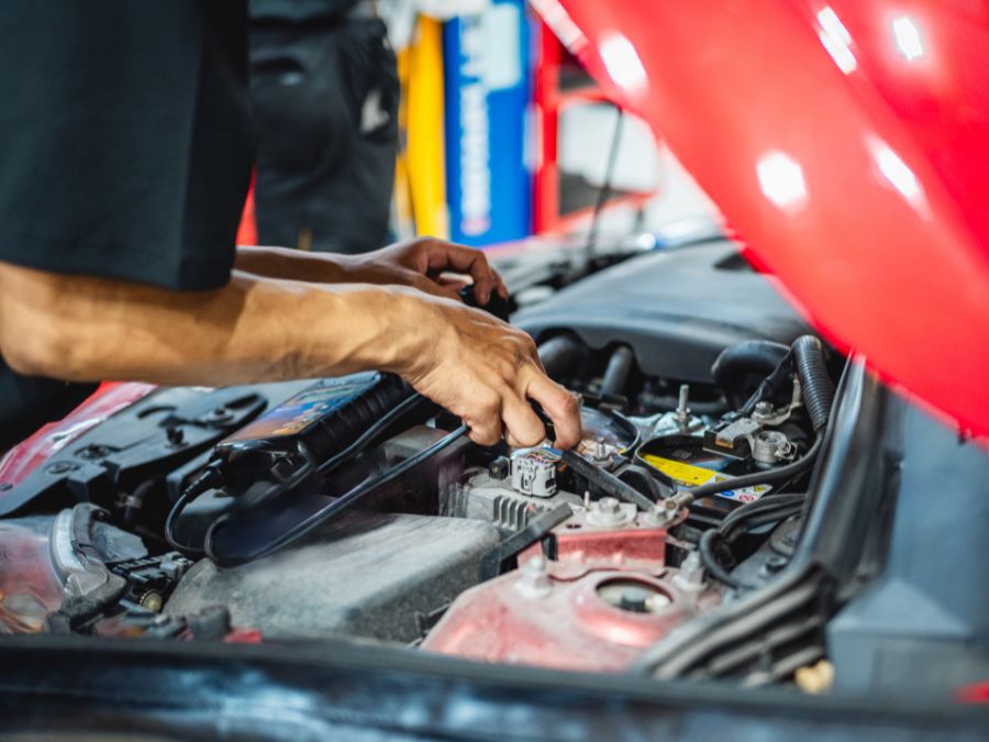 A technician in an auto body shop in Tempe, AZ, repairing a Tesla