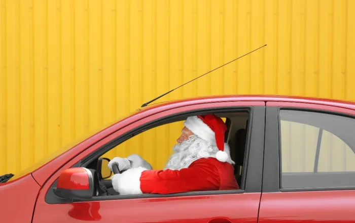Man in Santa Clause costume driving a red vehicle